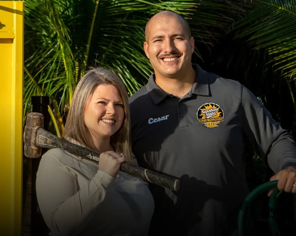Cesar and Lynzee Hurtado, owners of Sunshine State Junk Removal, beside a branded dump trailer